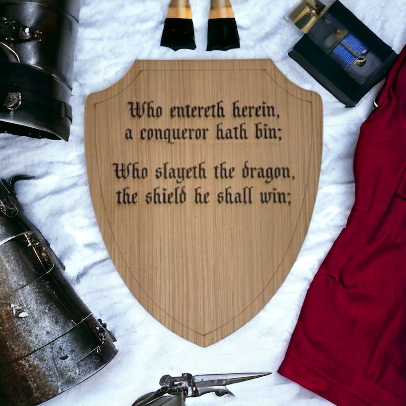 May include: A wooden shield with a medieval inscription: "Who entereth herein, a conqueror hath bin; Who slayeth the dragon, the shield he shall win;"