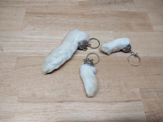 Real ethically-sourced rabbit foot keychains that lean hard into goblincore/oddity aesthetics — the kind of mummified curiosity that feels genuinely foraged, not factory-made.