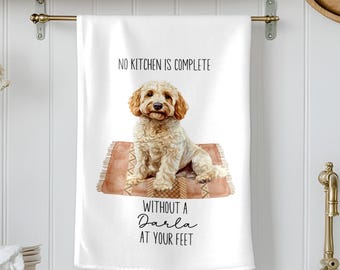 May include: White kitchen towel with the text "NO KITCHEN IS COMPLETE WITHOUT A Darla AT YOUR FEET." The towel features a watercolor illustration of a light brown dog sitting on a small rug with a brown and beige pattern.