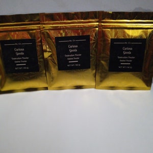 May include: Three gold foil pouches with black labels that read "Ms. G's Curious Goods Destruction Powder Satchet Powder NET WT. 1 OZ (28g)"