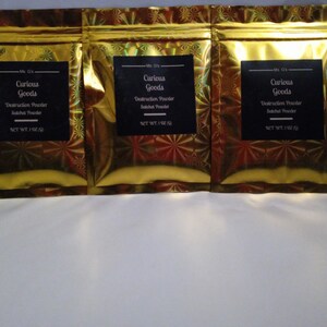 May include: Three gold foil pouches with black labels that read "Curious Goods" and "Destruction Powder Satchel Powder" with a net weight of 1 oz.