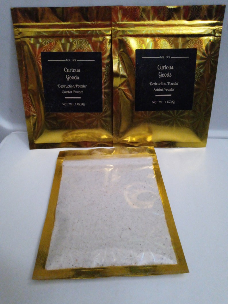 May include: Two gold foil pouches with a white powder inside. The pouches have black labels that read "Ms. G's Curious Goods Destruction Powder Satchet Powder NET WT. 1 OZ (28g)"