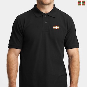 May include: A black short-sleeved polo shirt featuring a collar, a two-button placket, and a small embroidered Basque flag on the left chest. The flag consists of a red background with a green saltire and a white cross overlaid.