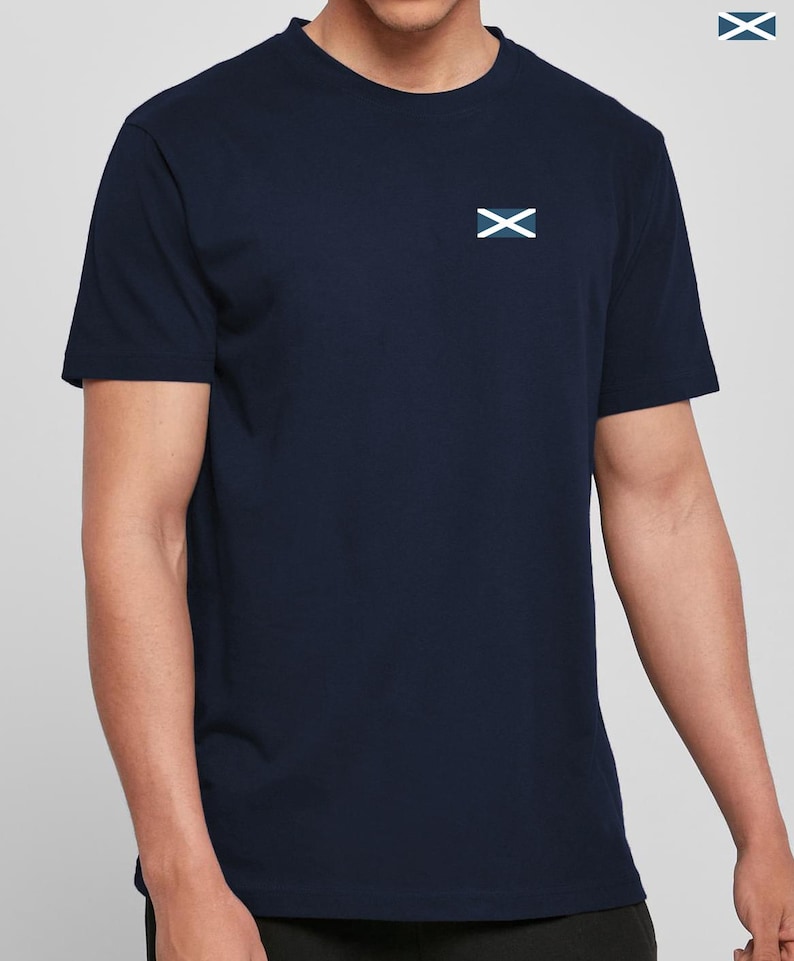 Op de afbeelding: Marineblauw T-shirt met een klein embleem van een wit en blauw vlag op de borst. Het shirt met korte mouwen heeft een ronde hals en is gemaakt van een zacht materiaal. Het embleem is een witte X op een blauwe achtergrond.