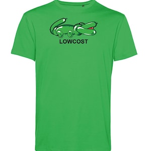May include: A bright green t-shirt featuring a cartoon alligator design in black and green with a red mouth. The word "LOWCOST" is printed in black below the alligator. The shirt is a solid, vibrant green.
