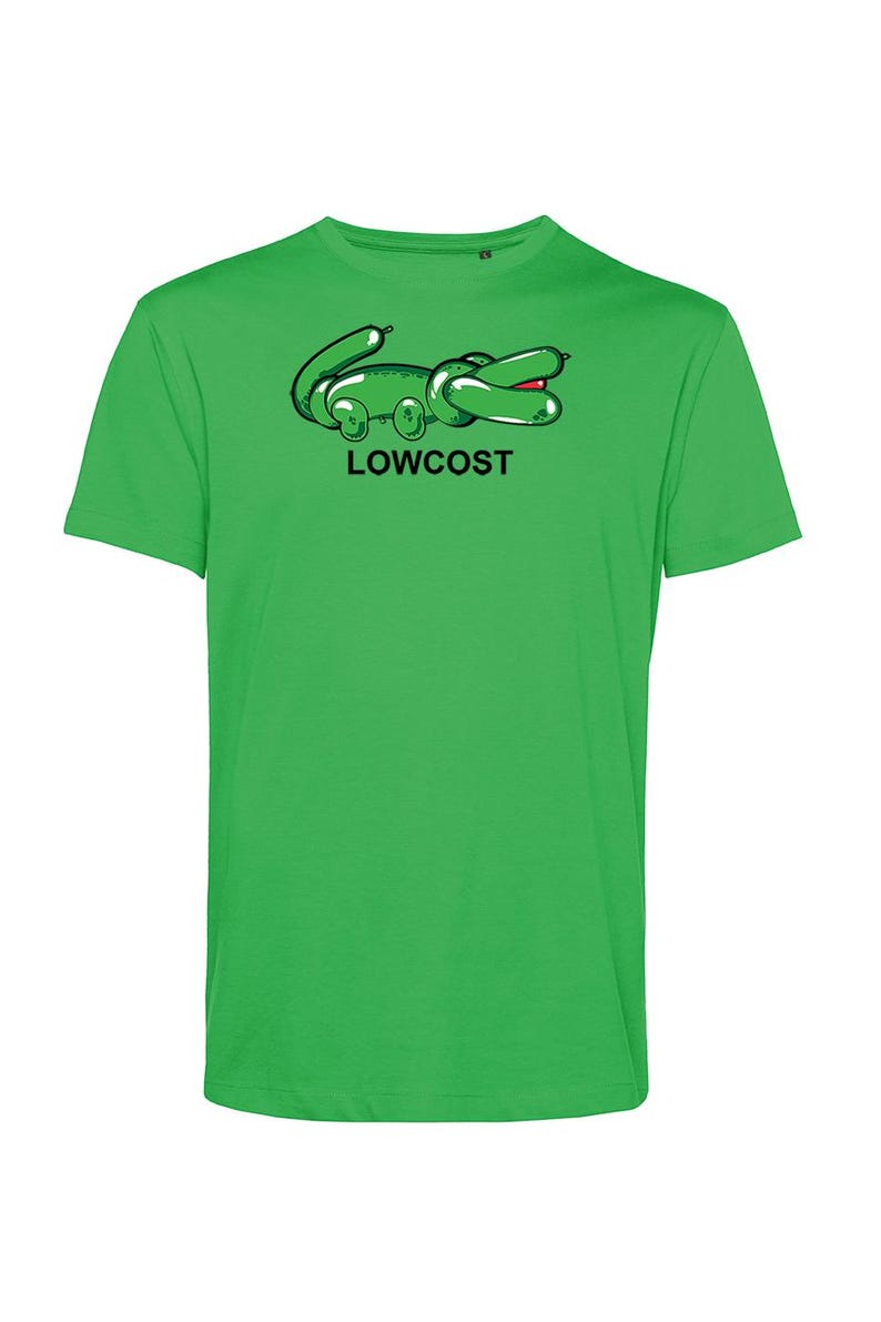 May include: A bright green t-shirt featuring a cartoon alligator design in black and green with a red mouth. The word "LOWCOST" is printed in black below the alligator. The shirt is a solid, vibrant green.