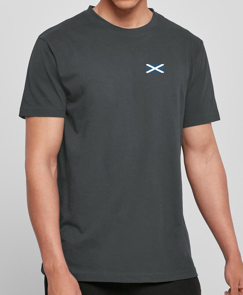 Op de afbeelding: Donkergrijs T-shirt met een klein wit en blauw Schots vlagembleem op de linkerborst. De top heeft korte mouwen en een ronde hals. De stof lijkt een zachte katoenmix te zijn.