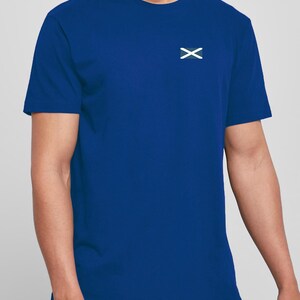 Op de afbeelding: Koningsblauw T-shirt met een wit 'X' logo op de linkerborst. Het shirt met korte mouwen is gemaakt van een zacht materiaal en heeft een klassieke ronde hals. Het shirt is effen van kleur, zonder andere zichtbare patronen of afbeeldingen.