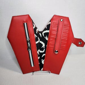 Cartera con forma de ataúd con dientes de vampiro brillantes