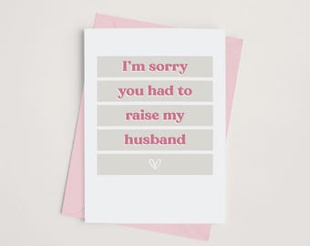 May include: A white card with a pink border and the text "I'm sorry you had to raise my husband" in pink letters on a gray background.