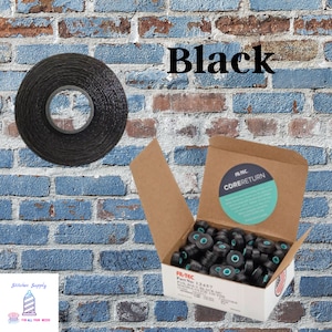 May include: Black thread spool and a box of black thread cores. The word "Black" is displayed in large font. The box is labeled "FIL-TEC" and "CORE RETURN". The background is a brick wall.