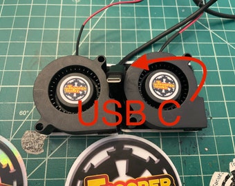 May include: Two black USB-C powered fans with a Trooper Tronix logo on each. The fans are connected to a USB-C cable.