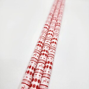 May include: Three white wrapping paper rolls with a red and white Christmas pattern featuring snowflakes, reindeer, and hearts.