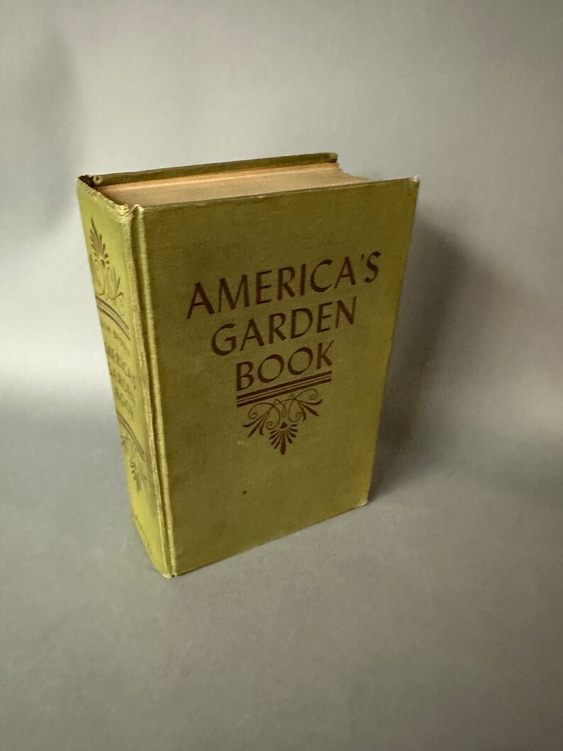May include: A vintage green book titled "America's Garden Book" with gold lettering and a decorative design.