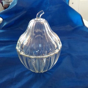 A clear ribbed glass pear shaped candy dish with a lid.  Bowl 858