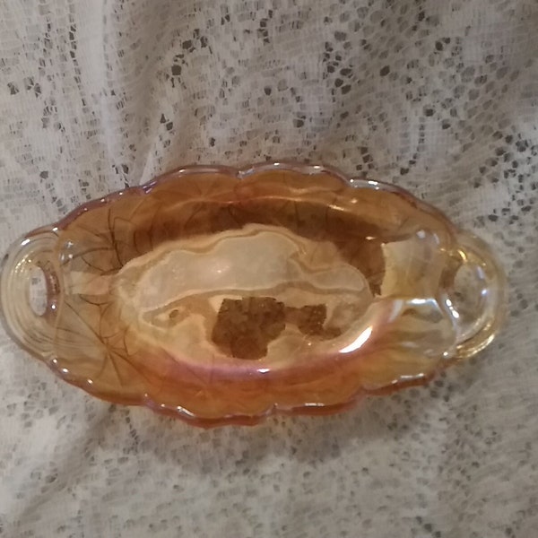 A oval Lily Pons relish or pickle dish with open handles made iridescent amber gold glass by Indiana Glass in the 1960s.  Bowl 957B