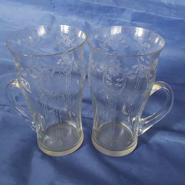 A pair of antique etched hot toddy, Irish coffee, or latte are 11 fluid ounce handled mugs that 5.25" tall.  Glass 621