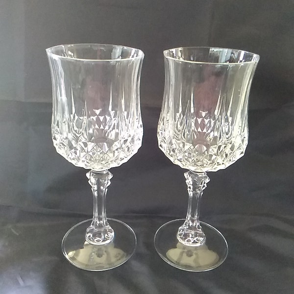 A matching pair of crystal Cristal d'Arques 7.5 oz wine glasses with diamond point pattern that is on the bowl and stem.  Bar 883