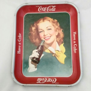 A 1950's metal Coca-Cola serving tray that a a young girl with red hair and a yellow scarf.   Misc 80u