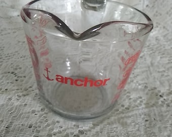 Anchor Hocking number 23 measuring cup that holds 16 oz or 2 cup measuring cup with red graphics. Dish 1186