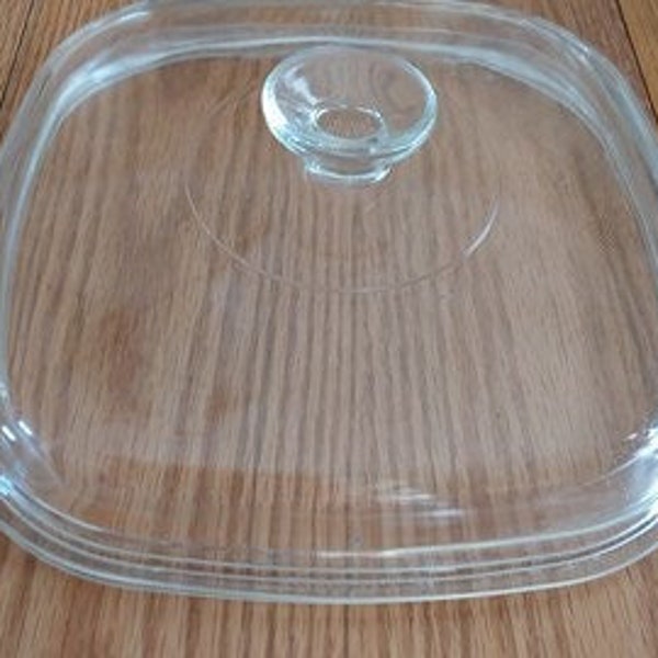 A clear square glass Pyrex replacement lid for a 9.75" inch pan that is marked A-12-C.   The lid measures 10.5" across.  CD 177