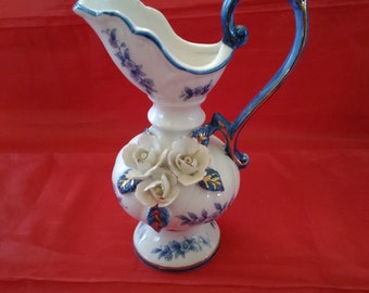 A Lego China white porcelain pitcher with white Capodimonte flowers with blue floral design with gold trim.  Misc 890
