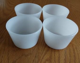 May include: Set of four white ceramic ramekins, each with a slightly flared rim.