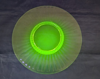 May include: A green glass plate with a fluted edge and a smaller green glass plate in the center.