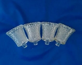 A set of 4 matching Indiana Glass clear 3" tall votive cups in their diamond point design on pegs.  Candle 295