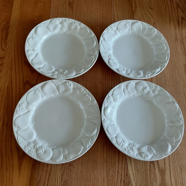 Marked Italy, a set of 4-10.75" white ceramic fruit embossed dinner plates by Este Ceramiche.  On the bottom is marked Este C. E. Plates 893