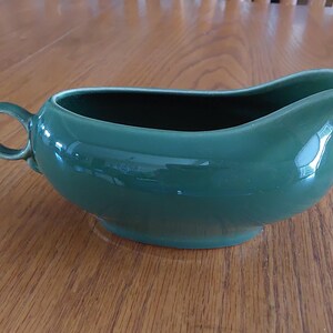 A Ballerina pottery green footed gravy boat with loop handle that was made by Universal.  It is circa 1950s, made in the USA.  Dish 2154
