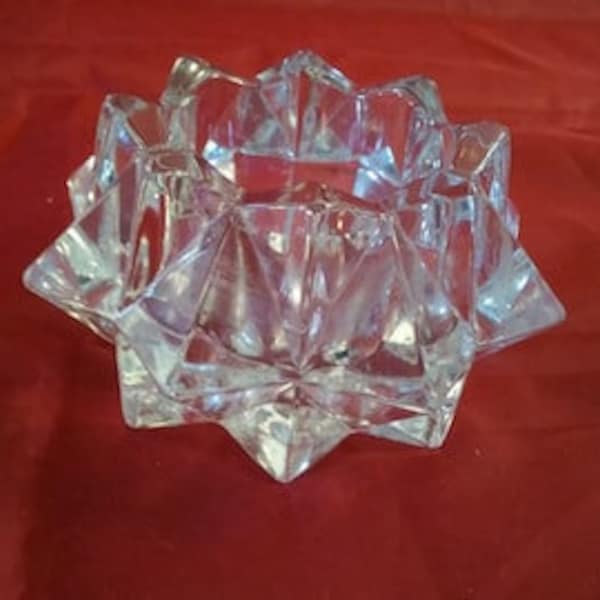 An Avon clear glass multi pointed starburst votive candle holder entitled Gem Glow from the 70's.  Avon C 81