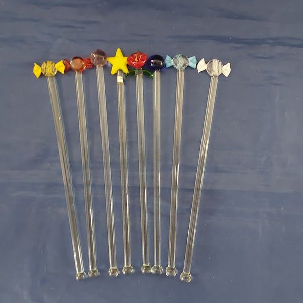 Eight Murano Glass like 8" swizzle sticks.  Four are wrapped candle, two are colored balls, one yellow star and one red flower.   Bar 1087