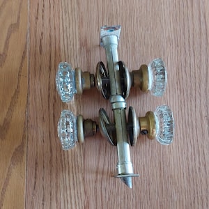 A set of 2 antique interior 12 pointed glass door knob sets withlatch assemblies and face plates with brass hardware.  Misc 2069