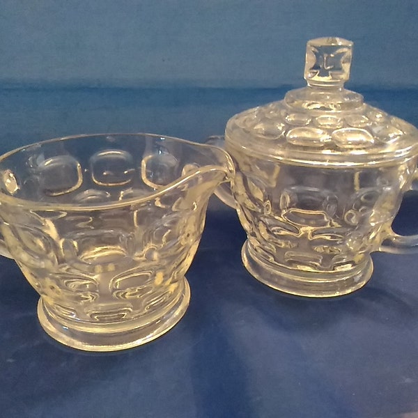 A Federal Glass Yorktown patterned colonial style matching clear glass footed sugar bowl with lid and creamer thumbprint design.  Dish 1442