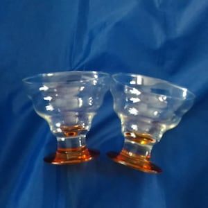 Matching set of 2 orange base 9 fluid ounce stemless martini glasses.  Bar 817