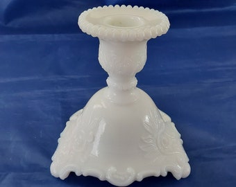 Westmoreland white milk glass candlestick holders sitting on 3 feet in the scroll and lace pattern, with their insignia on the base. MG  373