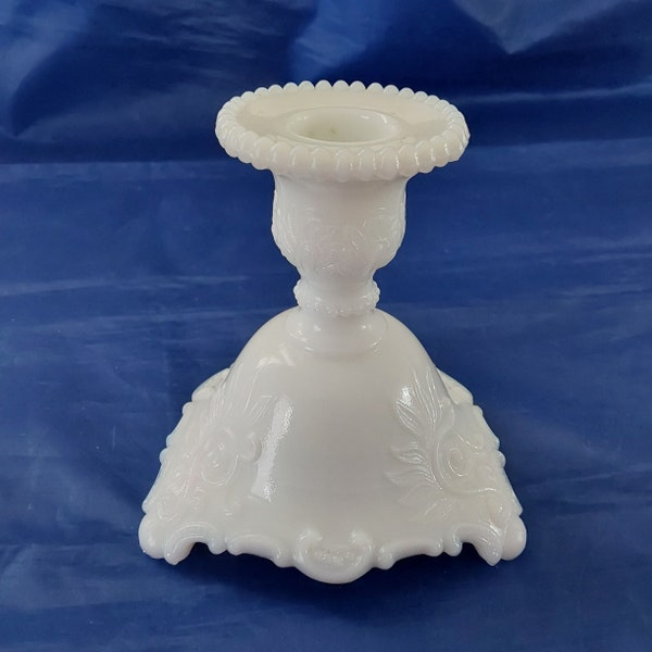 Westmoreland white milk glass candlestick holders sitting on 3 feet in the scroll and lace pattern, with their insignia on the base. MG  373