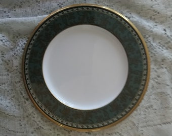 A Langsdale patterned Noritake 9.5" luncheon plate that is white porcelain with a leaf border on a green band with red accents.  Plate 516