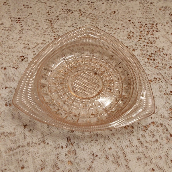 A pink depression glass  7" wide triangular shaped shallow dish with a zipper and square pattern.  Perfect for a trinket dish.  Bowl 1293