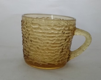 An amber gold Anchor Hocking 6 oz punch cup in the Soreno pattern that is textured bark like look.  Glass 223