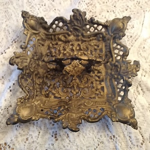 A cast black Iron Art reticulated footed candy dish painted gold with a handle.  Misc 1205