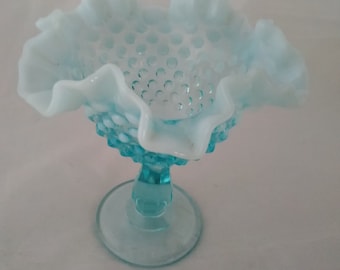 A blue marked Fenton stemmed compote in the hobnail patten with a moonstone double ruffled rim.  Misc 519