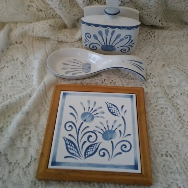 A matching trivet, spoon rest, napkin holder that is a 3 piece white ceramic set with blue trim by Jay Imports.  Dish 1284