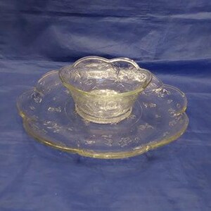 May include: A clear glass serving dish with a scalloped edge and a matching bowl. The dish and bowl are decorated with a floral pattern.