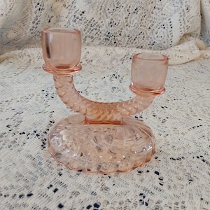 A pink Imperial Glass 2 arm swirled candle stick holder with a swirl design on an oval base.  Candle 485