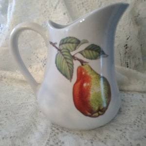 A BIA Cordon Bleu ivory ceramic 1 quart 7&quot; tall ceramic pitcher with a pear one side and a floral design on the other.  Pitcher 46