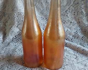 Stamped on the base, Canada Dry Gingerale Incorporated.  A set of 2-12 fl oz bottles are in an iridescent orange carnival glass.  Misc 2063