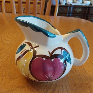 A hand painted Purinton slipware pottery 20 oz cream colored pitcher with a red apple and yellow pear design with an aqua trim.  Dish 1969