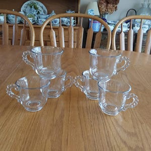 Six matching clear Imperial Glass punch cups with a unique beaded keyhole shaped handle.  Two sets of 6 for 12 cups available.  Glass 736